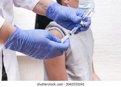 A boy at school getting vaccinated from covid-19, receiving a vaccine from sars-cov-2 virus - Powered by Shutterstock