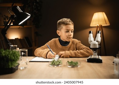 Boy scientist learning and writing science and researching through microscope in the home lab. Science and education concept - Powered by Shutterstock