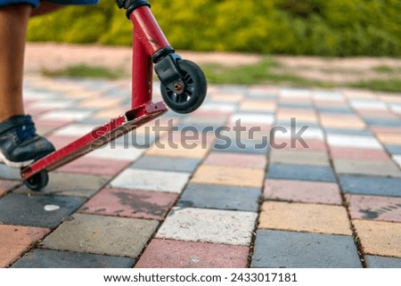 A boy with a scooter in the park, close-up on his feet and the scooter, epitomizing outdoor fun and childhood adventures. Stock photo © 