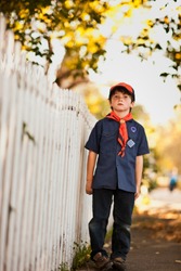 Boy Scout Standing On A Suburban Street.