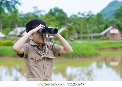 Boy Scout, A Thai Asian Young Boy Scout In Uniform Exploring With Binocular In The Forest