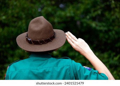 Boy scout in uniform performs three finger salute. Scout symbol hand gesture. France. 
