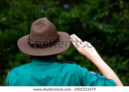 Boy scout in uniform performs three finger salute. Scout symbol hand gesture. France. 