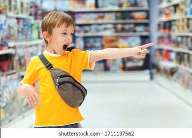 Boy Screams And Demands A Toy In The Store. Little Boy Getting Hysterical In Toy Shop. ?hildren's Tantrum In The Store. Shop Toys. Inside Toy Shop. Kid Makes Difficult Choice In Supermarket.