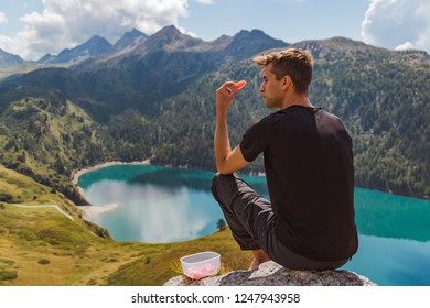 Boy Seated On The Peak Of The Mountain In The Swiss Alps, Tasting 
Refreshing Watermelon