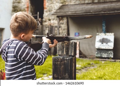 The Boy Shoots A Crossbow At The Target.