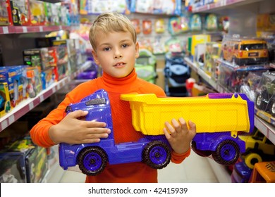 The Boy In Shop With Toy Truck In Hands