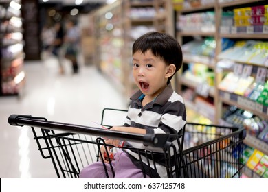 A Boy Is Shopping With His Mom In A Supermarket.