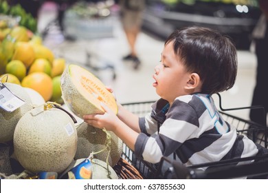 A Boy Is Shopping With His Mom In A Supermarket.