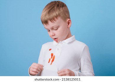 Boy showing a red stain spilled from tomato sauce on white clothes. The concept of cleaning stains on clothes. High quality photo - Shutterstock ID 2138125011
