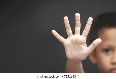 Boy showing STOP gesture with his hand. Concept of domestic violence and child abuse. Copy space