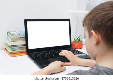 A Boy Sits At A Desk With A Laptop. Online Home Learning Concept. Mock Up Laptop PSD.