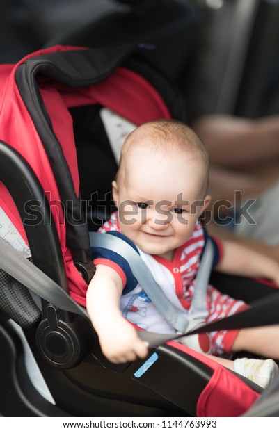 Boy sitting in a car in\
safety chair.