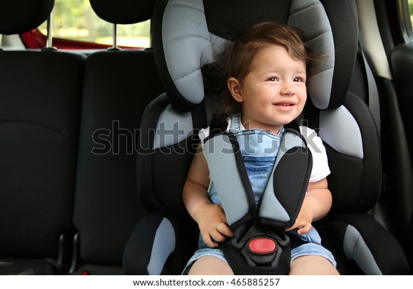Boy sitting in a car in\
safety chair