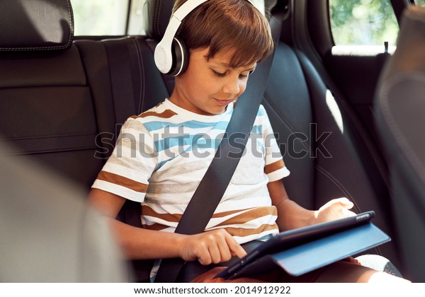 Boy sitting with a digital tablet in the car         \
                     