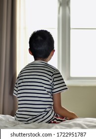 a boy sitting down looking out of a window - Shutterstock ID 1722951787