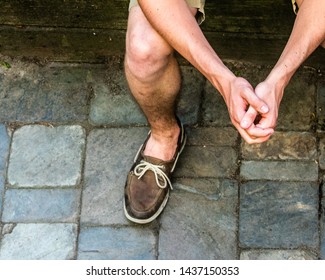 Boy Sitting With Hands Crossed In Sperry Shoes