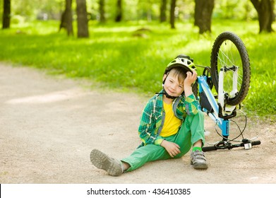 Boy Sitting Near A Broken Bicycle