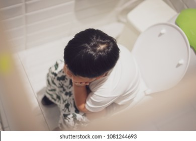 A Boy Is Sitting On Toilet With Suffering From Constipation Or Hemorrhoid.