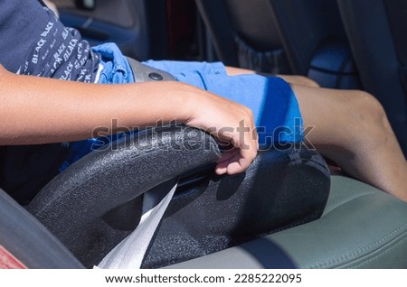 Boy sitting in safety booster car seat.