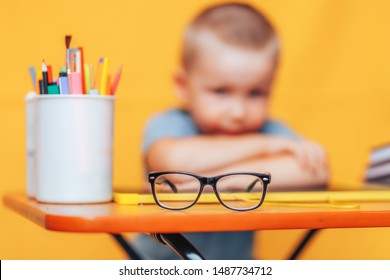 Boy Sitting Ubfocused Glasses In Focus. Concept Problem Of Ophthalmology Correction Of Myopia. Back To School. Selective Focus. Upset Child.