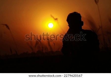A boy sitting under the sun in the fall afternoon watching the sunset and feeling lonely. A beautiful afternoon.sunset.alone boy.