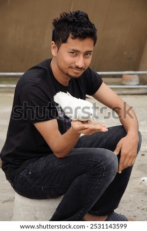 boy sitting while feeding a bird dove or pegion from hand palm on terrace or village countryside life.human-animal interaction, peaceful life pet care, wildlife interaction, pigeon feeding hand