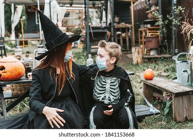 A Boy In A Skeleton Costume And A Girl In A Witch Costume Wearing A Protective Face Mask At A Halloween Party In A New Reality Due To The Covid Pandemic