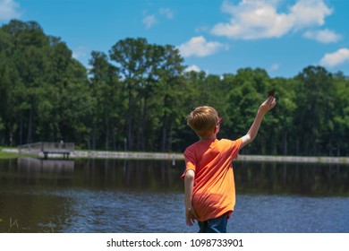 Boy Skipping Rocks