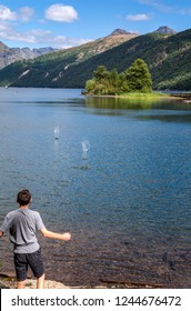 Boy Skipping Rocks On Water