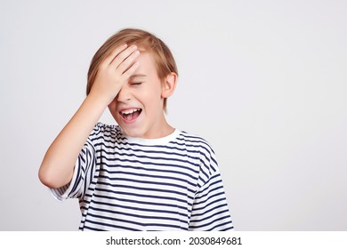 Boy slapping forehead with palm and closing eyes. Unhappy kid forgetting something. Face emotion and expression. Oops, what did I do. Back to school and news. Oh no. Boy thinking about mistakes.