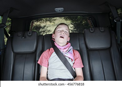 A Boy Sleeping In The Back Of A Car