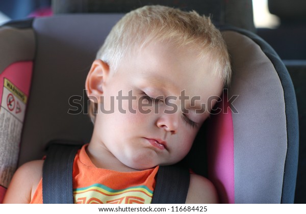 Boy is sleeping in a\
child car seat