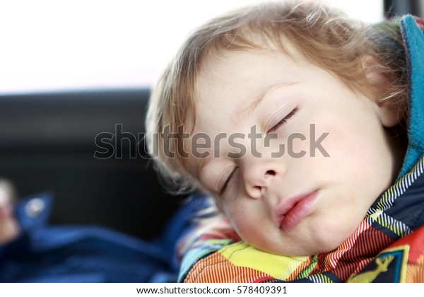 Boy sleeping in a child car\
seat