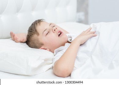 Boy Is Sleeping On The Bed With His Mouth Open, Snoring