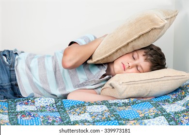 A Boy Is Sleeping On Bed In Noisy Room