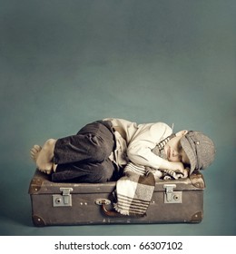 boy sleeping on a suitcase