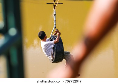 Boy sliding on a zipline in an adventure park - Powered by Shutterstock