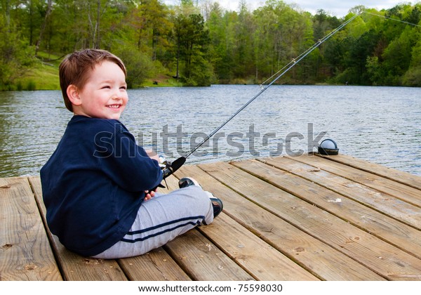 Boy Smiles While Fishing Dock On Stock Photo (Edit Now) 75598030