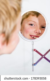 Boy Smiling And Looking In A Vanity Mirror