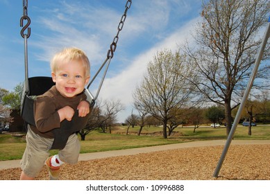 Boy Smiling On Swingset.