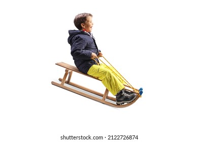 Boy smiling and sliding on a wooden sleigh isolated on white background - Powered by Shutterstock