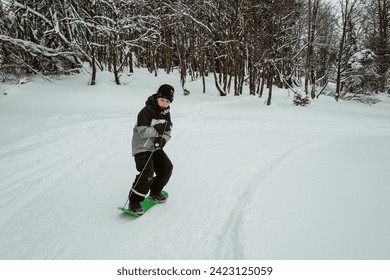 Boy snowboarding in winter snowy forest - Powered by Shutterstock