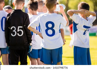 Boy Soccer Player Drinking Water from a Water Bottle During Soccer Half Time Break - Powered by Shutterstock