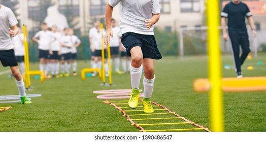 Boy Soccer Player In Training. Young Soccer Players At Practice Session. Boys Running Youth Agility Ladder Drills. Soccer Ladder Exercises