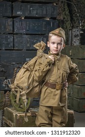 Boy Soldier Wearing A Cap With A Red Star Holding A Duffel Bag On His Shoulder