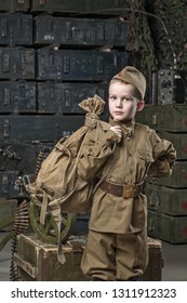 Boy Soldier Wearing A Cap With A Red Star Holding A Duffel Bag On His Shoulder