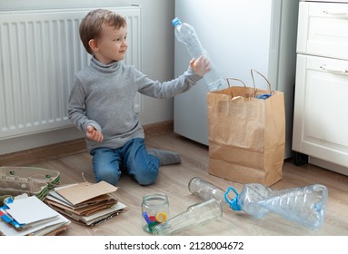 The boy is sorting garbage in the kitchen. Sorts paper, plastic, glass. The concept of zero waste. 3R concept: reduce, reuse, recycle