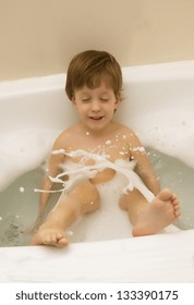 The boy splashes in a bathroom