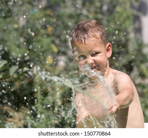 Boy Squirting Water From A Hose